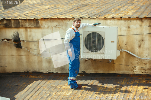 Image of HVAC technician working on a capacitor part for condensing unit