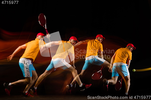 Image of One caucasian man playing tennis on black background