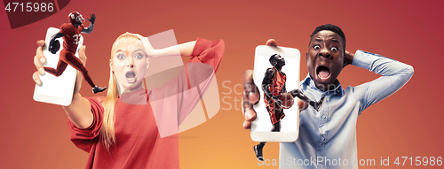 Image of Portrait of people showing screen of mobile phone isolated over orange background