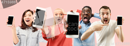 Image of Portrait of people showing screen of mobile phone isolated over coral background