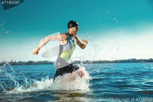Image of Professional triathlete swimming in river\'s open water