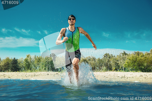 Image of Professional triathlete swimming in river\'s open water