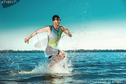 Image of Professional triathlete swimming in river\'s open water