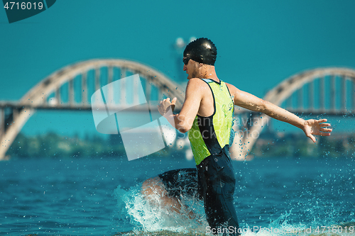 Image of Professional triathlete swimming in river\'s open water