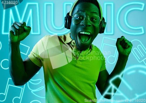 Image of Beautiful young man isolated on studio background in neon light