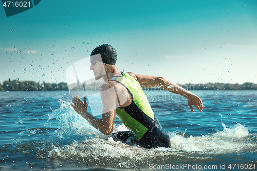 Image of Professional triathlete swimming in river\'s open water