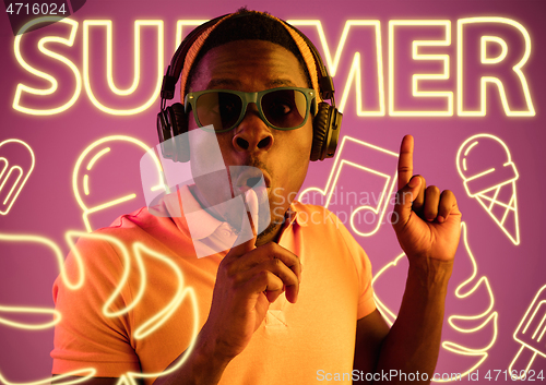 Image of Beautiful young man isolated on studio background in neon light