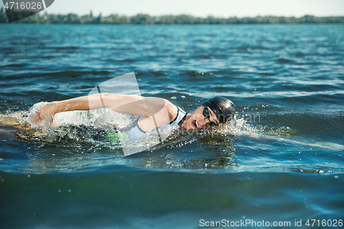 Image of Professional triathlete swimming in river\'s open water