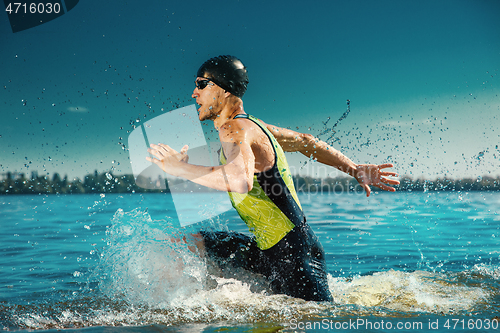 Image of Professional triathlete swimming in river\'s open water