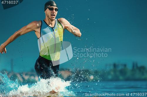 Image of Professional triathlete swimming in river\'s open water