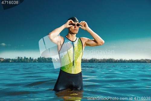 Image of Professional triathlete swimming in river\'s open water