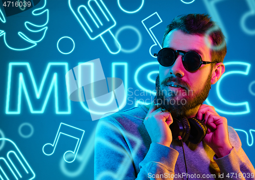 Image of Beautiful young man isolated on studio background in neon light