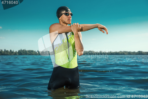 Image of Professional triathlete swimming in river\'s open water