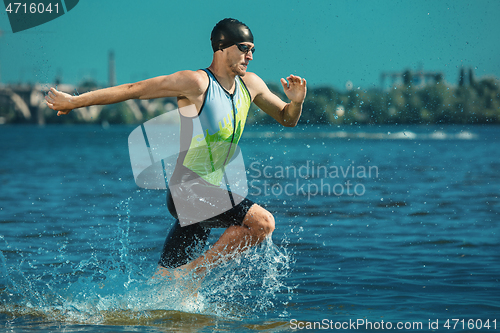 Image of Professional triathlete swimming in river\'s open water