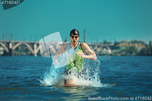 Image of Professional triathlete swimming in river\'s open water