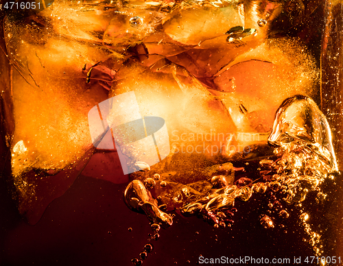 Image of Close up view of the ice cubes in dark cola background