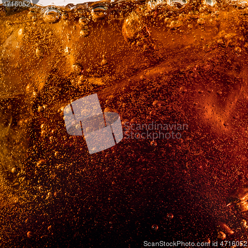 Image of Close up view of the ice cubes in dark cola background