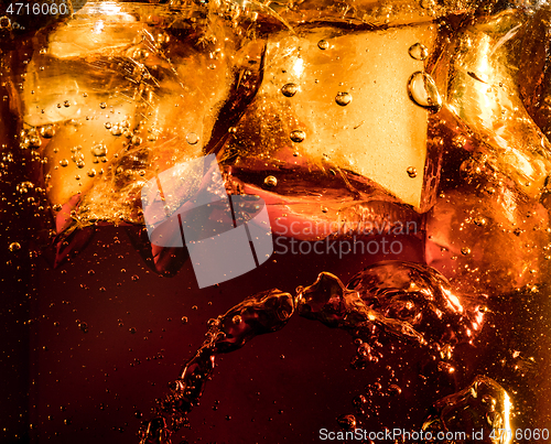 Image of Close up view of the ice cubes in dark cola background