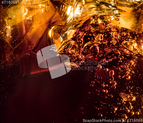 Image of Close up view of the ice cubes in dark cola background