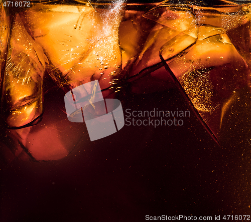 Image of Close up view of the ice cubes in dark cola background