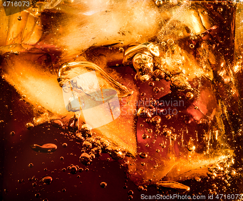 Image of Close up view of the ice cubes in dark cola background