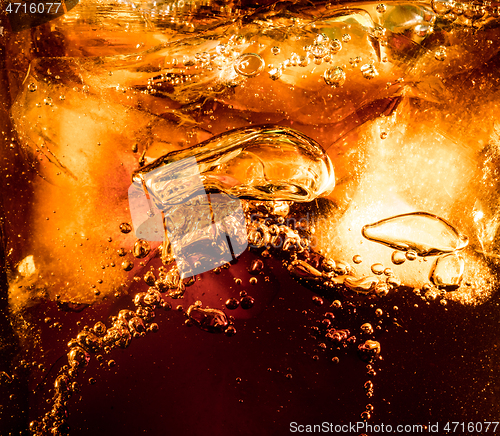 Image of Close up view of the ice cubes in dark cola background