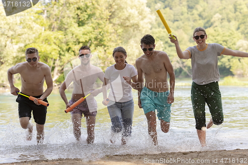 Image of group of happy friends having fun on river