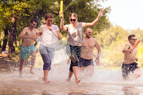 Image of group of happy friends having fun on river