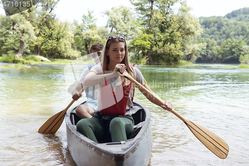 Image of friends are canoeing in a wild river