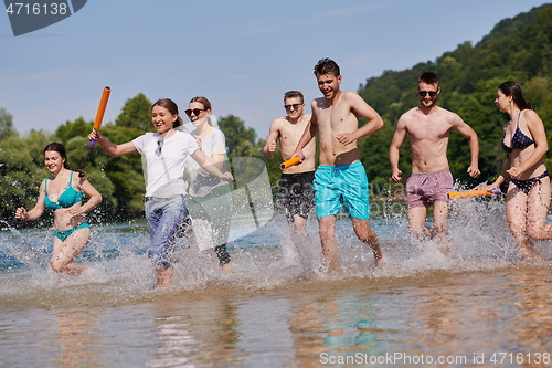 Image of group of happy friends having fun on river