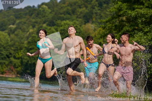 Image of group of happy friends having fun on river