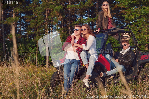 Image of group young happy people enjoying beautiful sunny day while driving a off road buggy car