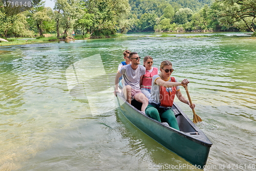 Image of Group adventurous explorer friends are canoeing in a wild river