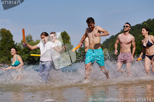 Image of group of happy friends having fun on river