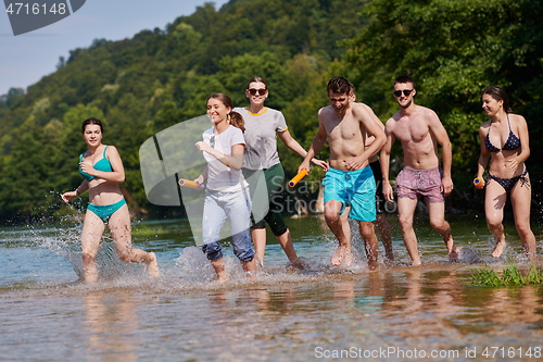 Image of group of happy friends having fun on river