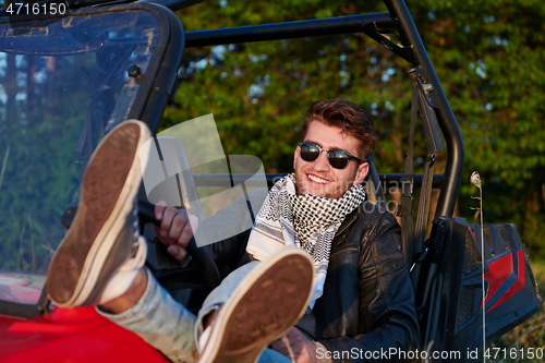 Image of man enjoying beautiful sunny day while driving a off road buggy car