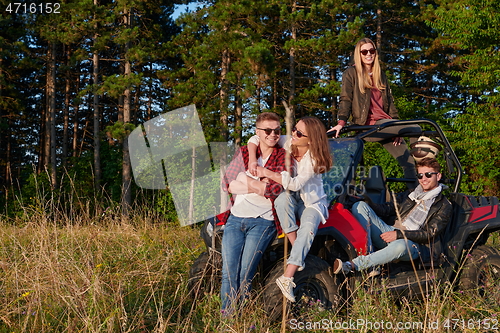 Image of group young happy people enjoying beautiful sunny day while driving a off road buggy car