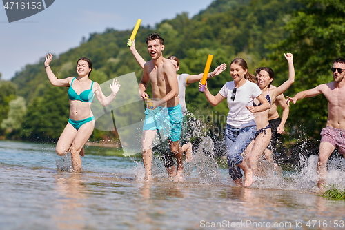 Image of group of happy friends having fun on river