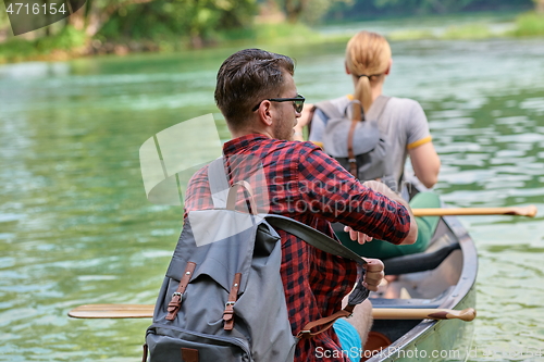 Image of friends are canoeing in a wild river