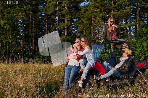 Image of group young happy people enjoying beautiful sunny day while driving a off road buggy car