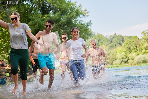 Image of group of happy friends having fun on river