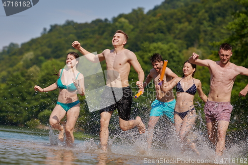 Image of group of happy friends having fun on river