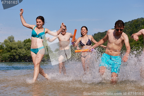 Image of group of happy friends having fun on river