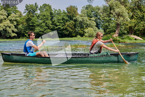 Image of friends are canoeing in a wild river