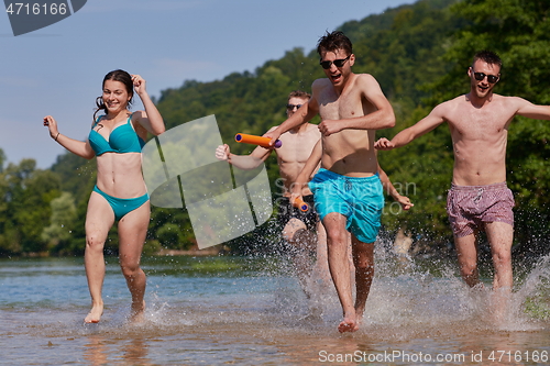 Image of group of happy friends having fun on river