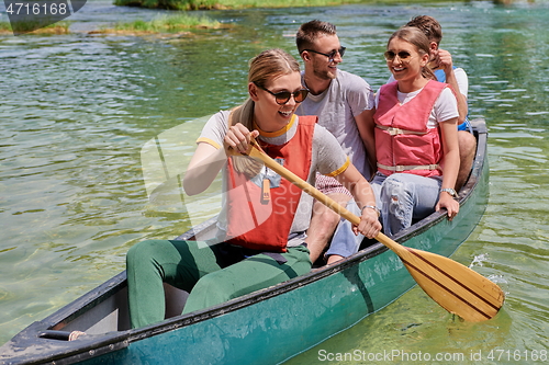 Image of Group adventurous explorer friends are canoeing in a wild river