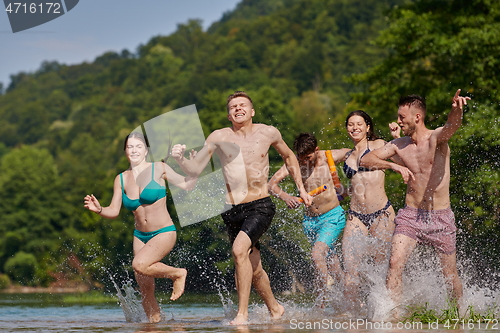 Image of group of happy friends having fun on river