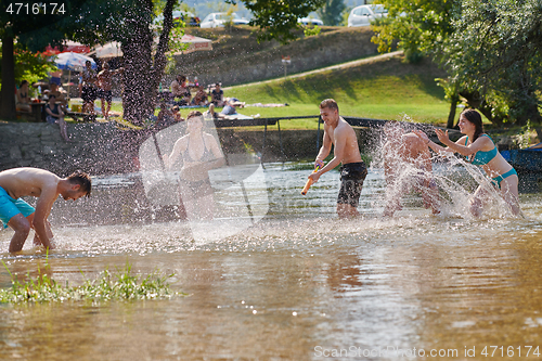 Image of group of happy friends having fun on river