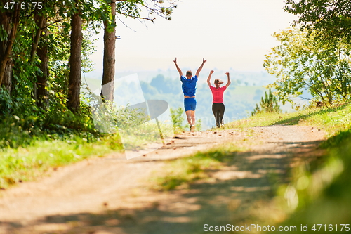 Image of couple enjoying in a healthy lifestyle while jogging on a country road