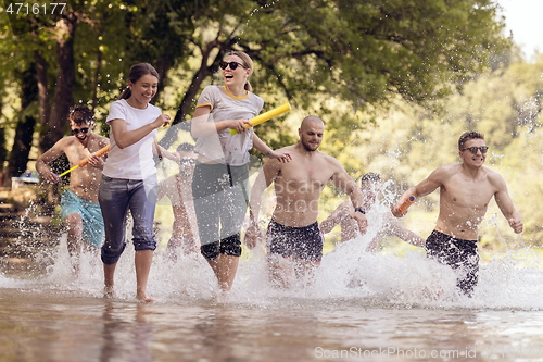 Image of group of happy friends having fun on river